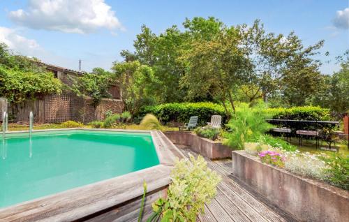 une piscine dans un jardin avec une terrasse en bois dans l'établissement Cozy Home In Dun With Wifi, à Dun