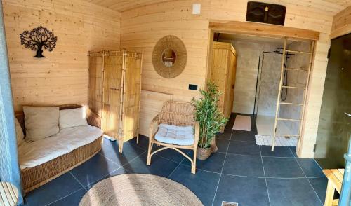 ein Zimmer mit einem Sofa und einem Stuhl in einem Zimmer in der Unterkunft Chalet avec bain nordique et sauna à Dabo in Dabo