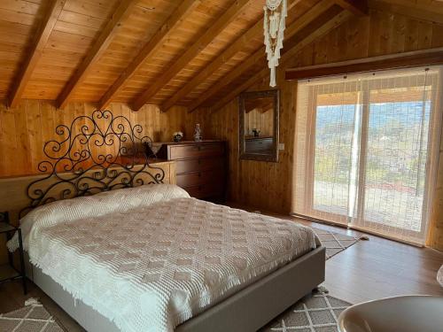 a bedroom with a bed and a large window at Quintinha da Mariana - Charming in the Douro Valley in Cinfães