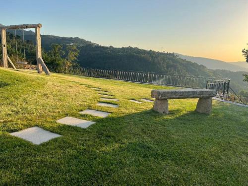 a stone bench sitting on top of a grass field at Quintinha da Mariana - Charming in the Douro Valley in Cinfães