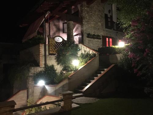 a house with stairs leading up to a building at night at BALMA DEI CUP con SPA privata su richiesta in Pont Canavese