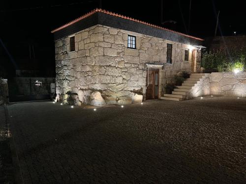 a stone building with a door and stairs at night at Quintinha da Mariana - Charming in the Douro Valley in Cinfães
