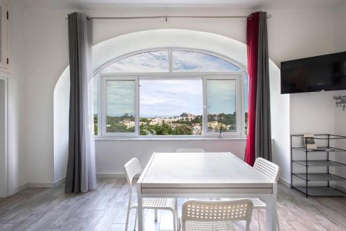 a dining room with a table and a window at Appartamento con vista esclusiva sul Golfo d'Ischia in Ischia
