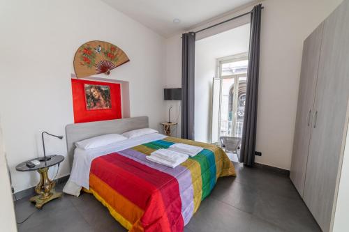 - une chambre avec un lit et une couverture colorée dans l'établissement Arka Apartments, à Naples