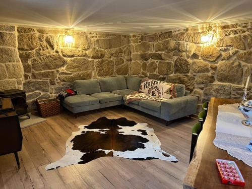 a living room with a couch and a stone wall at Quintinha da Mariana - Charming in the Douro Valley in Cinfães