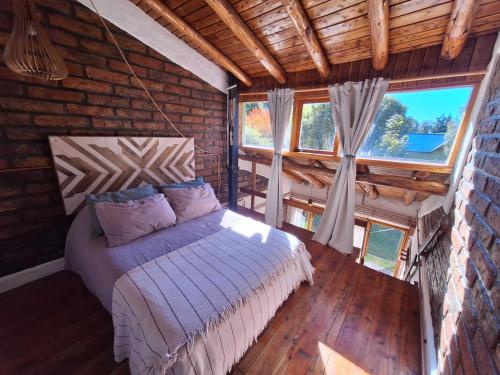 a bedroom with a bed in a log cabin at Bungalows Luz del sur in San Carlos de Bariloche