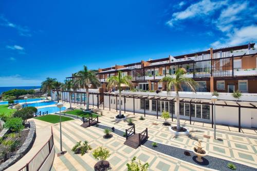 an apartment complex with a pool and palm trees at Ocean view perfect sunset apartment, 4 rooms 137m2, WiFi & BBQ in San Miguel de Abona