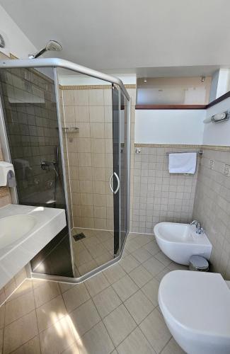 a bathroom with a shower and a toilet and a sink at Guest House & Villa Astoma in Palanga