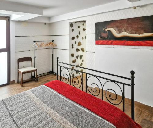 グイマルにあるOne bedroom apartement with sea view and enclosed garden at Guimar 4 km away from the beachのベッドルーム1室(ベッド1台付)が備わります。壁には絵画が飾られています。