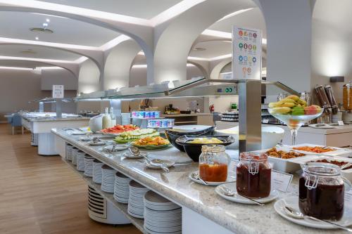 Una línea de buffet con platos de comida en ella en Jupiter Albufeira Hotel - Family & Fun - All Inclusive, en Albufeira
