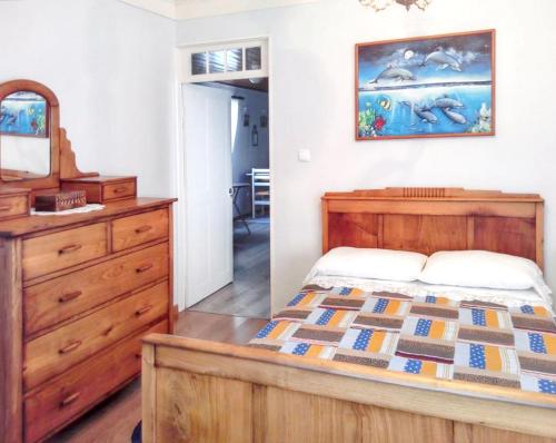een slaapkamer met een bed, een dressoir en een spiegel bij 3 bedrooms house with sea view furnished garden and wifi at Santo Amaro 2 km away from the beach in Santo Amaro