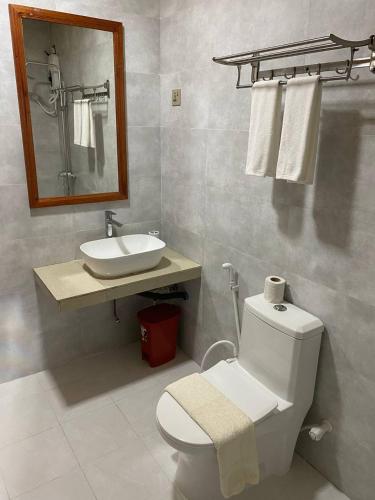 a bathroom with a white toilet and a sink at White Sand Inn in Maamigili