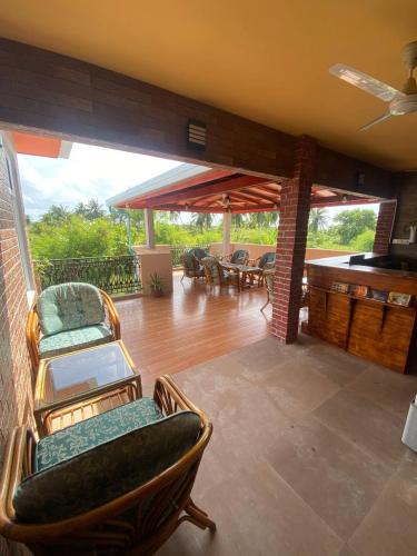 a living room with chairs and a deck with tables at White Sand Inn in Maamigili