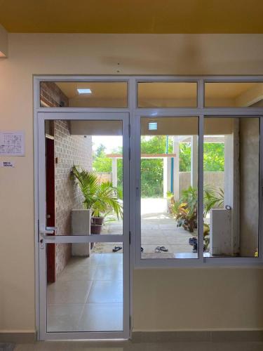 an open door to a patio with plants outside at White Sand Inn in Maamigili