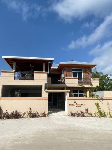 a large house with a balcony on the side of it at White Sand Inn in Maamigili