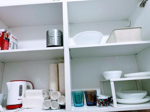a white pantry with dishes and other items on shelves at HOME SWEET HOME Antonella in Valenzano