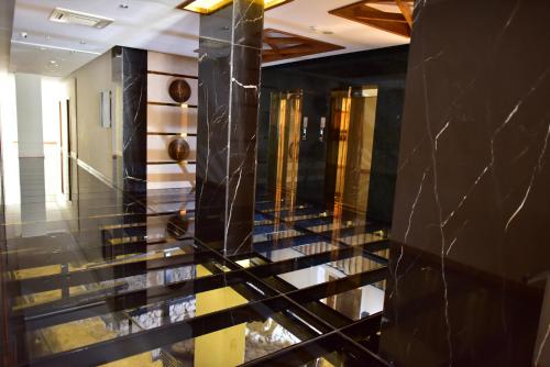 a lobby with black marble and gold columns at Giritligil Hotel in Manisa