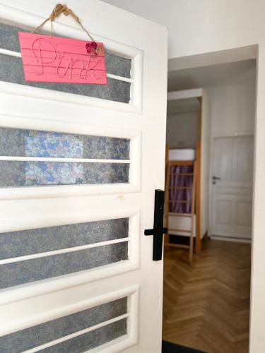 a door with a pink sign on it at Centrum House Hostel in Braşov