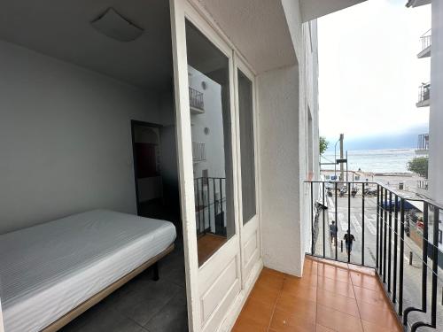 1 dormitorio con 1 cama y balcón con vistas al océano en Agi Macià Centro, en Roses