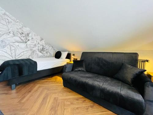 a living room with a couch and a bed at Hotel Millennium in Przasnysz