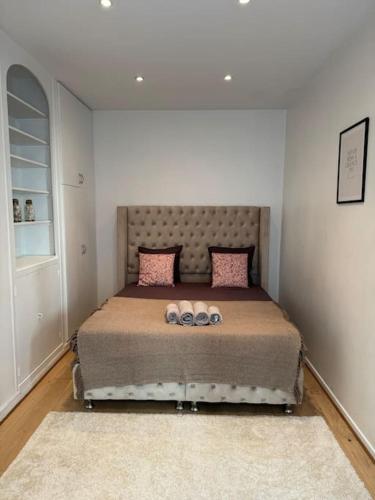 une chambre avec un grand lit avec des oreillers roses dans l'établissement Charmant Appartement au Moulin Rouge, à Paris