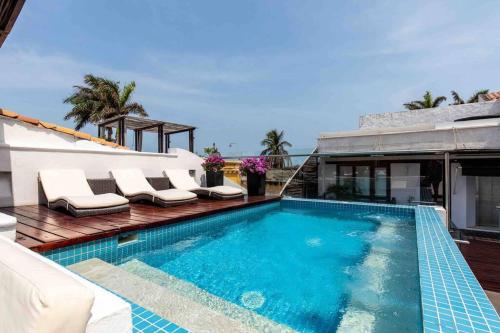 ein Swimmingpool mit Liegestühlen neben einem Haus in der Unterkunft Casa Gastelbondo in Cartagena de Indias