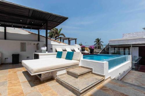 eine Terrasse mit einem Sofa und einem Pool in der Unterkunft Casa Gastelbondo in Cartagena de Indias