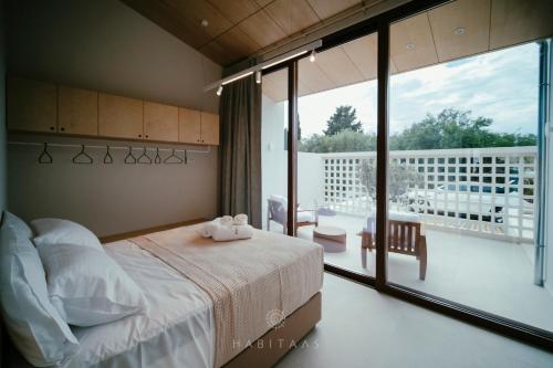 Un dormitorio con una cama y vista a un balcón. en Habitals villa, en Sivota