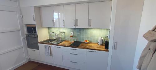 une cuisine avec des armoires blanches et un comptoir en bois dans l'établissement 