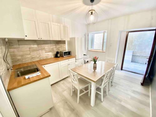 a kitchen with a wooden table and a table and chairs at My house in Pag in Pag
