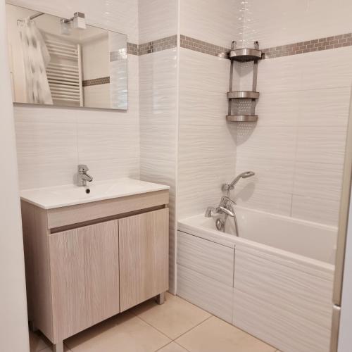 une salle de bain avec une baignoire et un lavabo et une baignoire tubermottermott dans l'établissement T2 Paris Disneyland Jardin Parking, à Noisy-le-Grand