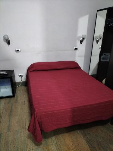 a bed in a room with a red blanket at Hotel MontReal in Rome