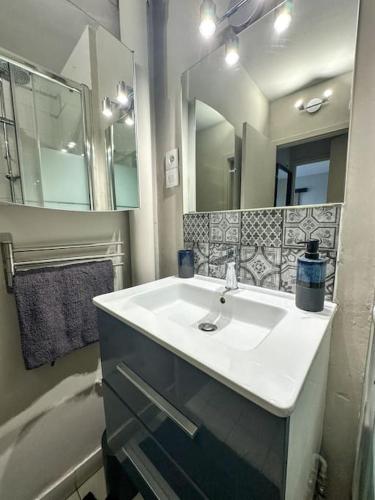 une salle de bain avec un lavabo et un miroir dans l'établissement Charmant T2 aux portes de Paris, à Aubervilliers