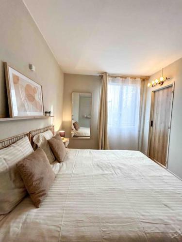 a bedroom with a large white bed with pillows at Charmant T2 aux portes de Paris in Aubervilliers