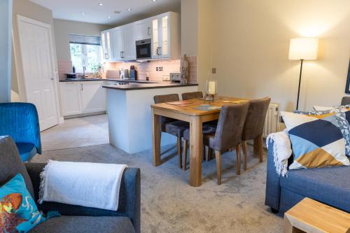 a kitchen and living room with a table and chairs at Luxury Apartments - MBS Lettings in Bewdley