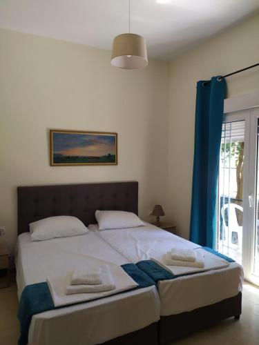 a bedroom with a large bed with a blue curtain at Mirkashouse in Limenas