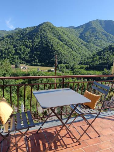 a white table and chairs on a balcony with mountains at Ilgattonero in Orero