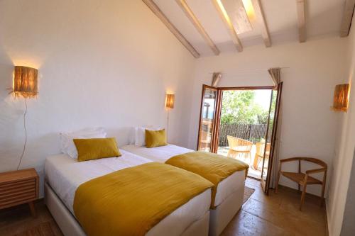 um quarto com uma cama com um cobertor amarelo em Aldeamento Turistico da Prainha em Alvor