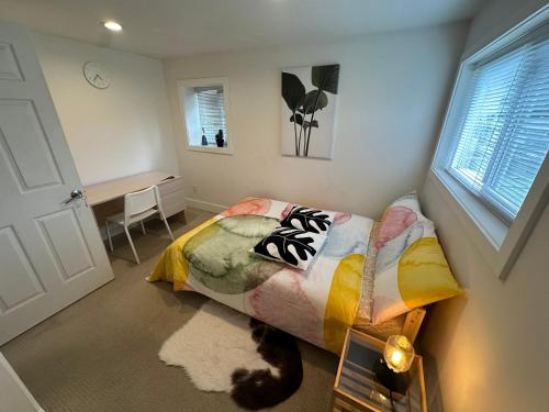 a bedroom with a bed and a cat laying on the floor at Private room in a Shared house in Vancouver