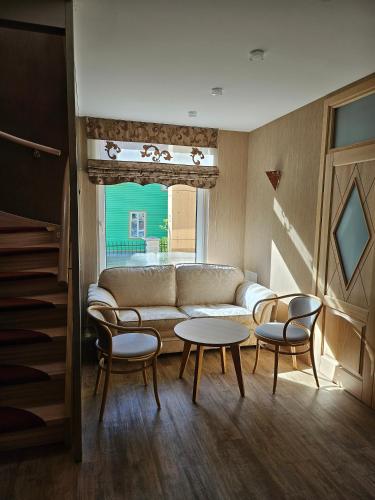 a living room with a couch and chairs and a table at Guest House & Villa Astoma in Palanga