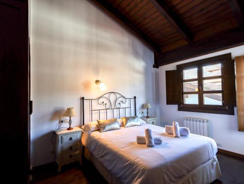 Un dormitorio con una cama con dos zapatos. en Sol Badaguas Jaca, en Jaca