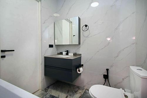 un bagno con lavandino, WC e specchio di Orion a Almaty