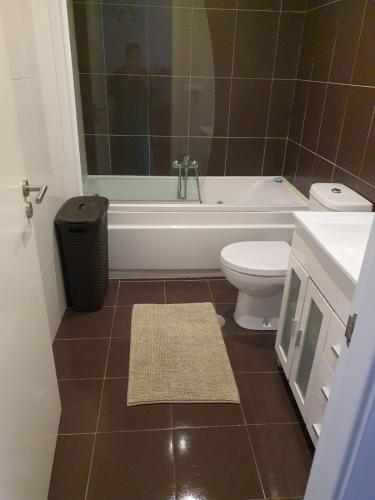 a bathroom with a tub and a toilet and a sink at Apartamento en Playa de Altar in Barreiros