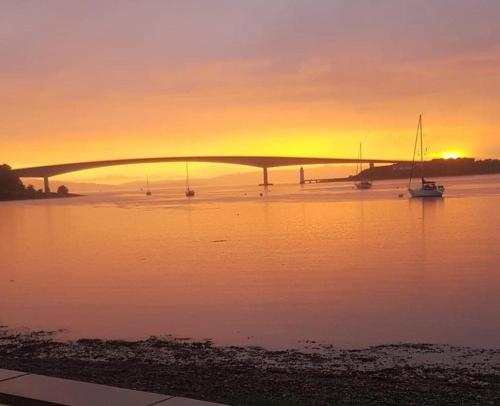 a bridge over a body of water at sunset at Ruisgarry Accommodation in Breakish