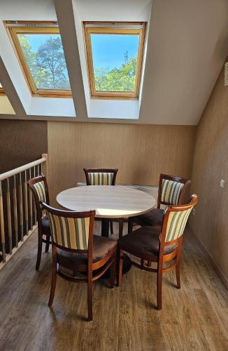 a table and chairs in a room with skylights at Guest House & Villa Astoma in Palanga
