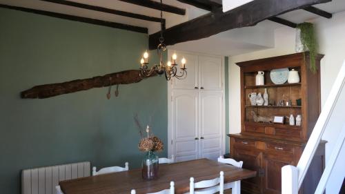 una sala da pranzo con tavolo in legno e lampadario pendente di Le Moulin du Clapier Le Viennois a Sorges