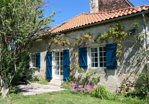 una vecchia casa con persiane blu e fiori di Le Moulin du Clapier Le Viennois a Sorges