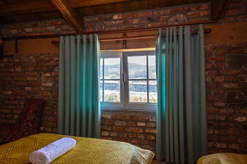 a bedroom with a bed and a window with curtains at Hani i Taulant Shahinit in Gramsh