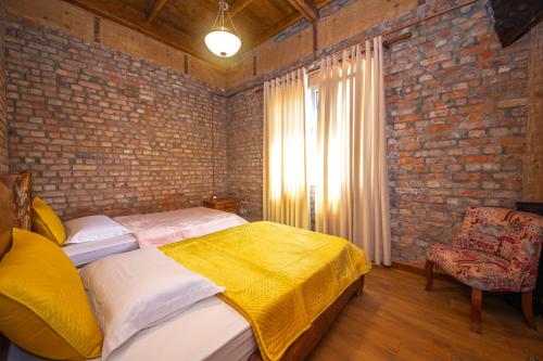 a bedroom with a bed and a brick wall at Hani i Taulant Shahinit in Gramsh