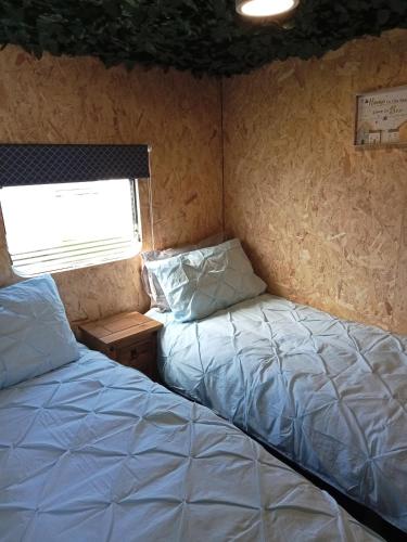 two beds in a small room with a window at 6 Headwards Glamping Retreat in Hemsby